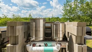 Estufa de camping portátil con dos ollas de acero inoxidable y un recipiente para agua.