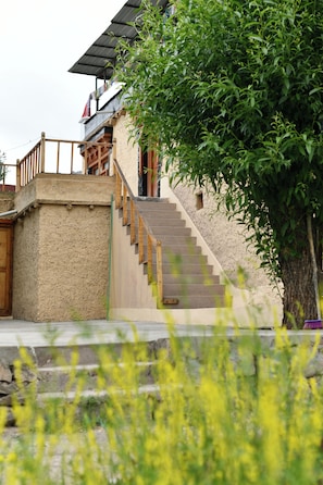 Un edificio tradicional con una escalera que lleva a un balcón de madera.