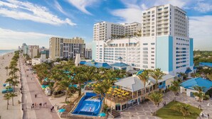 Un resort con varias edificaciones, playa y zona de piscina.