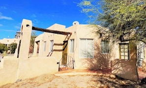 A building with a unique architectural style, featuring a prominent archway and a small porch area.