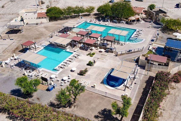 See the largest heated pool at El Dorado Ranch from above. El Cachanilla features three separate pools: main swimming pool, volleyball pool, and jacuzzi pool — tennis courts located right next to it.