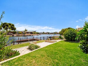 A waterfront property with a grassy lawn, a dock, and a body of water. - Canal view • Pet friendly • Private Jetty • Spacious Yard (South Yunderup)