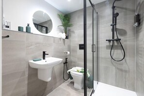 A modern bathroom with a sink, toilet, and shower. - Modern City Apartment - Sleeps 4 & Walk to Arena (Leeds)