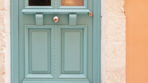 A turquoise door with a window, a small balcony, and a round doorknob. - La Luna della Loggia A1 (Rethymno)