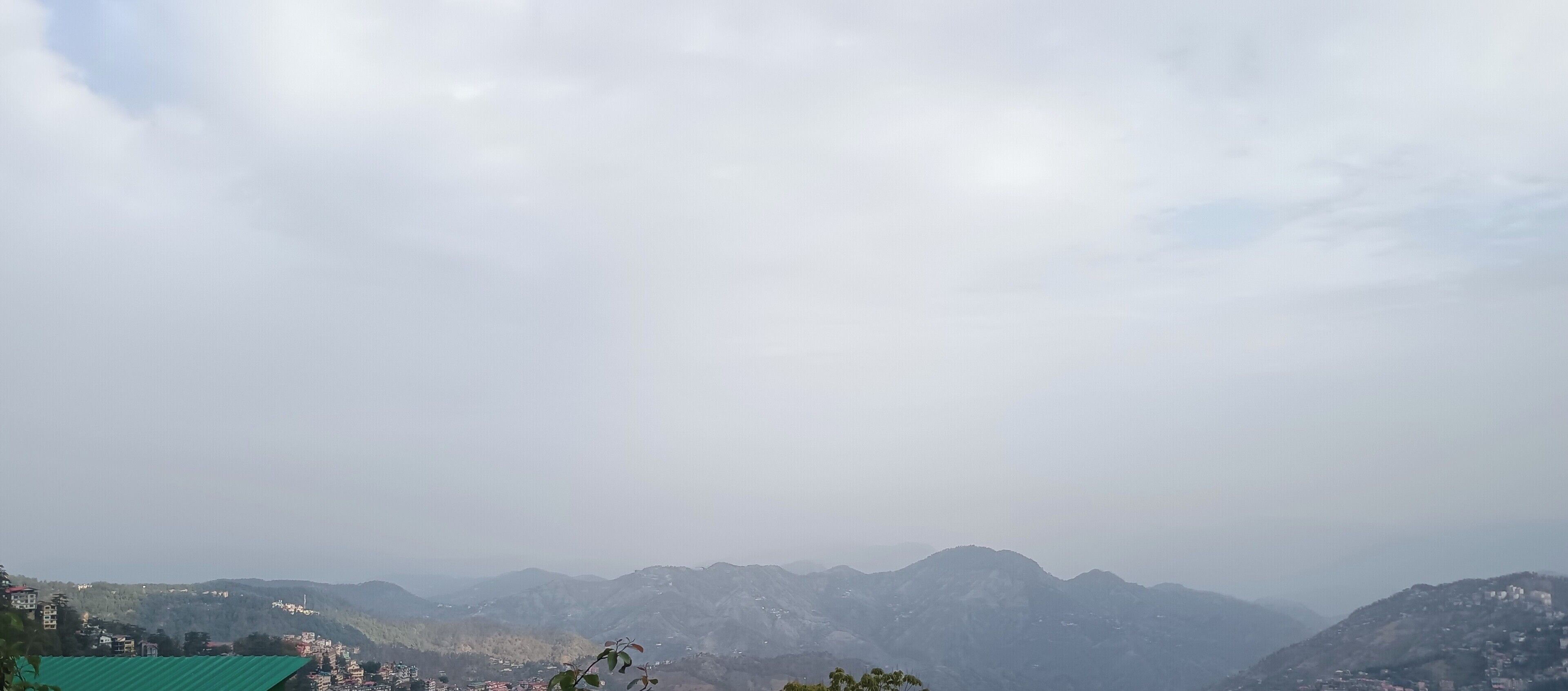 A mountainous landscape with a view of distant hills and a few buildings.