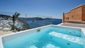 Piscina en la azotea con vistas despejadas a un pueblo costero y al mar.