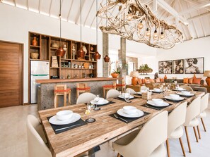 A modern kitchen with a wooden island, built-in shelves, and a hanging light fixture. - Swiss 2 Villa in Dalung (Tibubeneng)