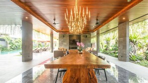 Un comedor amplio con una gran mesa de madera, asientos cómodos y una lámpara moderna.
