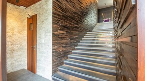 Una escalera flanqueada por un muro de madera y uno de piedra.