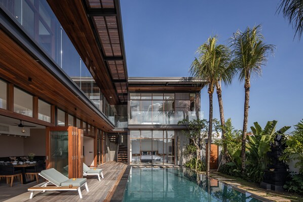 A modern house with a pool, wooden deck, and tropical plants. - Villa Dayu in Dalung (Tibubeneng)