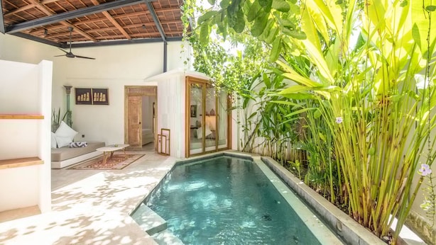 A pool area with a ceiling fan, a sofa, and a glass door leading to another room. - BA Villa 5 1 Bed Villa 5 Mins to Every Exquisite 1-br Villa With Pool 4 Mins to Echo Be (Canggu)