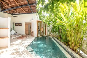 A pool area with a ceiling fan, a sofa, and a glass door leading to another room. - BA Villa 5 1 Bed Villa 5 Mins to Every Exquisite 1-br Villa With Pool 4 Mins to Echo Be (Pererenan)
