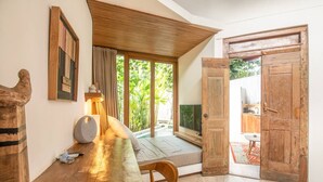 A cozy room with a wooden table, a chair, a lamp, and a large window with curtains. - BA Villa 5 1 Bed Villa 5 Mins to Every Exquisite 1-br Villa With Pool 4 Mins to Echo Be (Canggu)