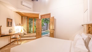 A bedroom with a large bed, a desk with a chair, and a view of a swimming pool through an open door. - BA Villa 5 1 Bed Villa 5 Mins to Every Exquisite 1-br Villa With Pool 4 Mins to Echo Be (Canggu)