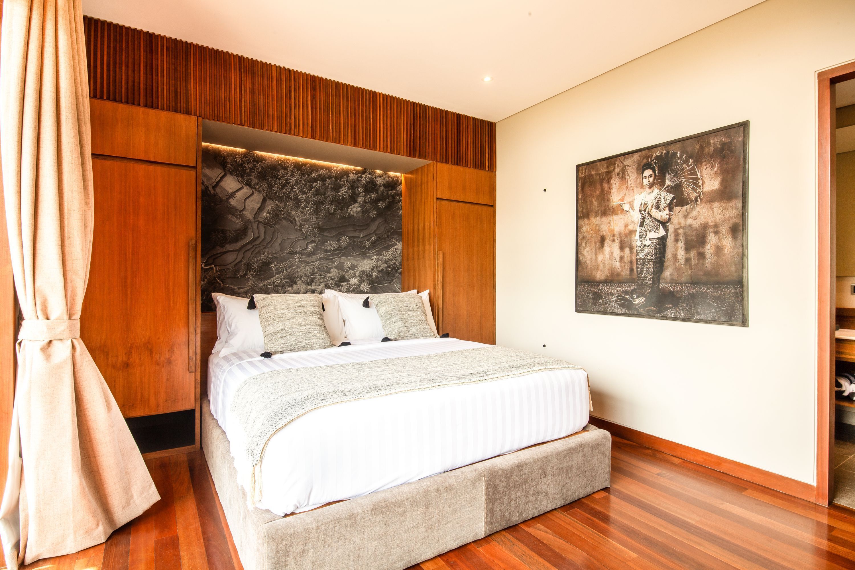 Ein Schlafzimmer mit einem großen Bett, Holzvertäfelung, einer Wandgestaltung aus Steinoptik und einem gerahmten Bild an der Wand.