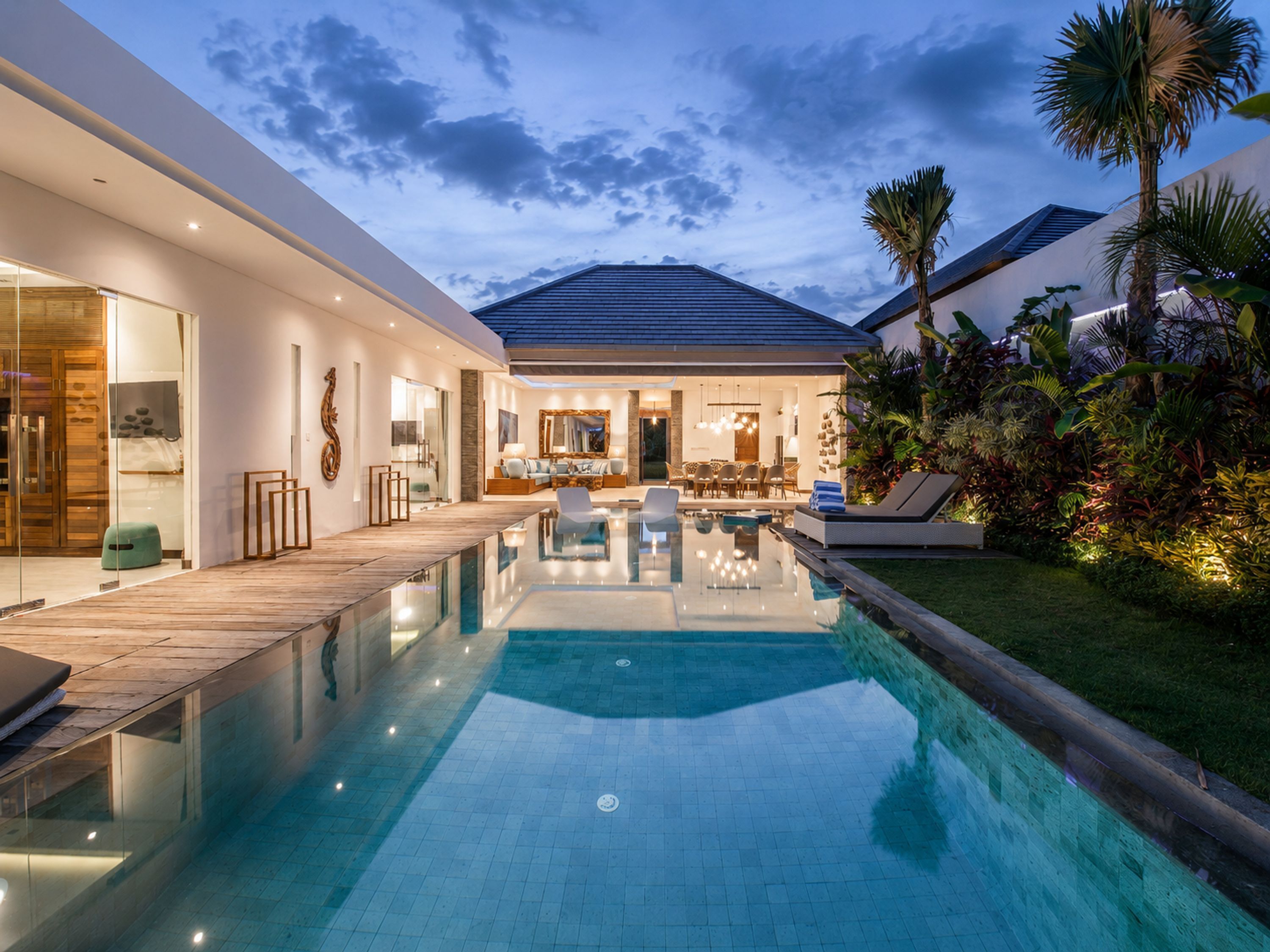 Ein modernes Haus mit Pool, Terrasse und einem gepflegten Garten.