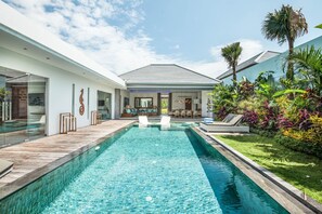A modern house with a swimming pool, outdoor seating, and tropical plants. - Marina Villa in Seminyak (Seminyak)