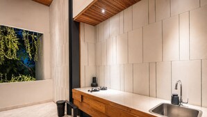 A modern kitchen with a wooden countertop, a stainless steel sink, and a view of greenery through a window. - BAZ Villa 13 Studio 3 Opulent 1-br Loft With Art Deco Shared Pool (Pererenan)