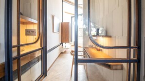 A narrow hallway with a wooden bench, a small table, and a microwave on the left. - BAZ Villa 13 Studio 3 Opulent 1-br Loft With Art Deco Shared Pool (Pererenan)