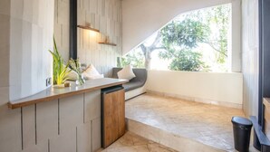 A modern kitchen with a wooden countertop, built-in dishwasher, and a seating area with a gray sofa and white cushions. - BAZ Villa 13 Studio 3 Opulent 1-br Loft With Art Deco Shared Pool (Pererenan)