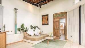 A modern living room with a sofa, a small round table, and a green rug. - BA Villa 2 1BR Elegant 1-br Villa With Pool 800m to Echo Beach (Canggu)