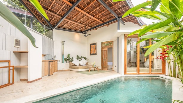 A pool area with a seating area, a kitchen, and a door leading to another room. - BA Villa 2 1BR Elegant 1-br Villa With Pool 800m to Echo Beach (Canggu)