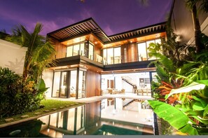 A modern house with a swimming pool, large windows, and a staircase leading to the upper floor. - Noma 2 Villa in Pererenan (Pererenan)