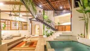 Amplio espacio interior con piscina, escalera y sofá.