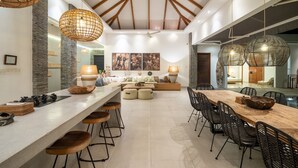 A spacious kitchen with a long island, bar stools, and pendant lighting. - Canggu Julia 2 in Dalung (Tibubeneng)
