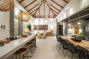 A spacious kitchen with a long island, bar stools, and pendant lighting. - Canggu Julia 2 in Dalung (Tibubeneng)