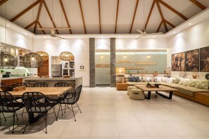 A modern interior with a kitchen, dining area, and living room. - Canggu Julia 2 in Dalung (Tibubeneng)