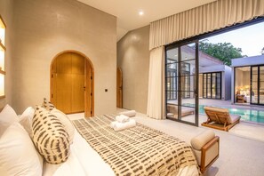 Une chambre avec un grand lit, une armoire en bois et une vue sur une piscine.