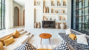 A modern living room with a sofa set, a coffee table, and a fireplace. - Villa Serai 5br to the Beach (Pecatu)