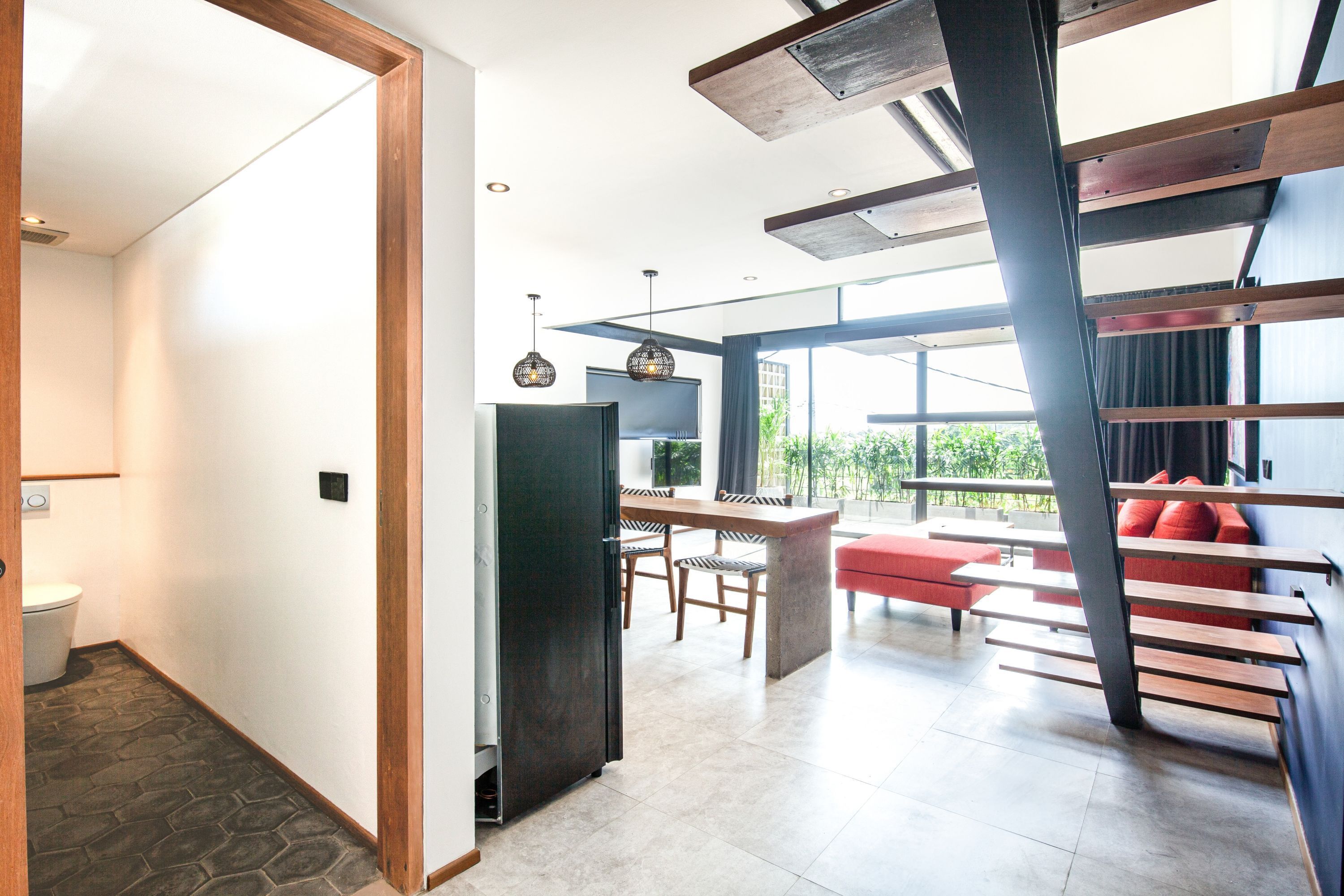 Un interior moderno con una escalera, un comedor y una cocina.