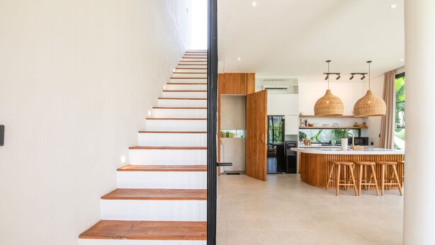 A modern kitchen with a central island, wooden bar stools, and pendant lighting. - San Marco Modern 2br Villas Beach 5mins Canggu (Canggu)