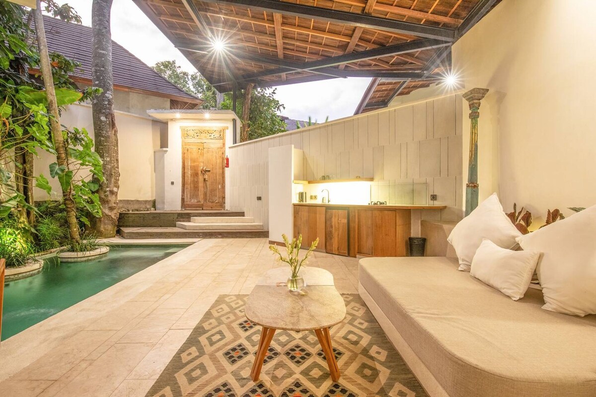 A cozy outdoor living area with a pool, a sofa, and a small table.