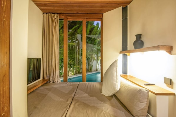A bedroom with a large window, a wooden ceiling, a bedside table, and a bed. - BA Villa 4 1BR Lush 1-br Villa With Pool 4 Mins to Echo Beach (Canggu)