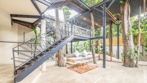 A spacious indoor area with a staircase, a sofa, and a coffee table. - BA Villa 10 2 BR Stylish 2-br Villa With Pool 800m Canggu Beach (Pererenan)