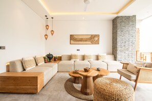 A modern living room with a sectional sofa, wooden coffee table, and a stone accent wall.
