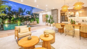 A modern outdoor living area with a pool, seating, and a bar. - SOL n2 Villa in Dalung (Tibubeneng)