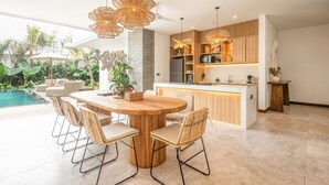 A modern kitchen with a central island, wooden cabinetry, and pendant lighting. - SOL n2 Villa in Dalung (Tibubeneng)