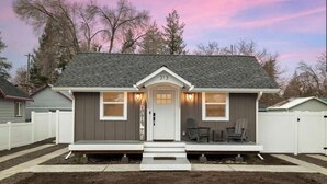 A single-story house with a front porch, a garage, and a small deck area. - Freshly Updated Hideaway in CDA’s Best Spot (Coeur d'Alene)
