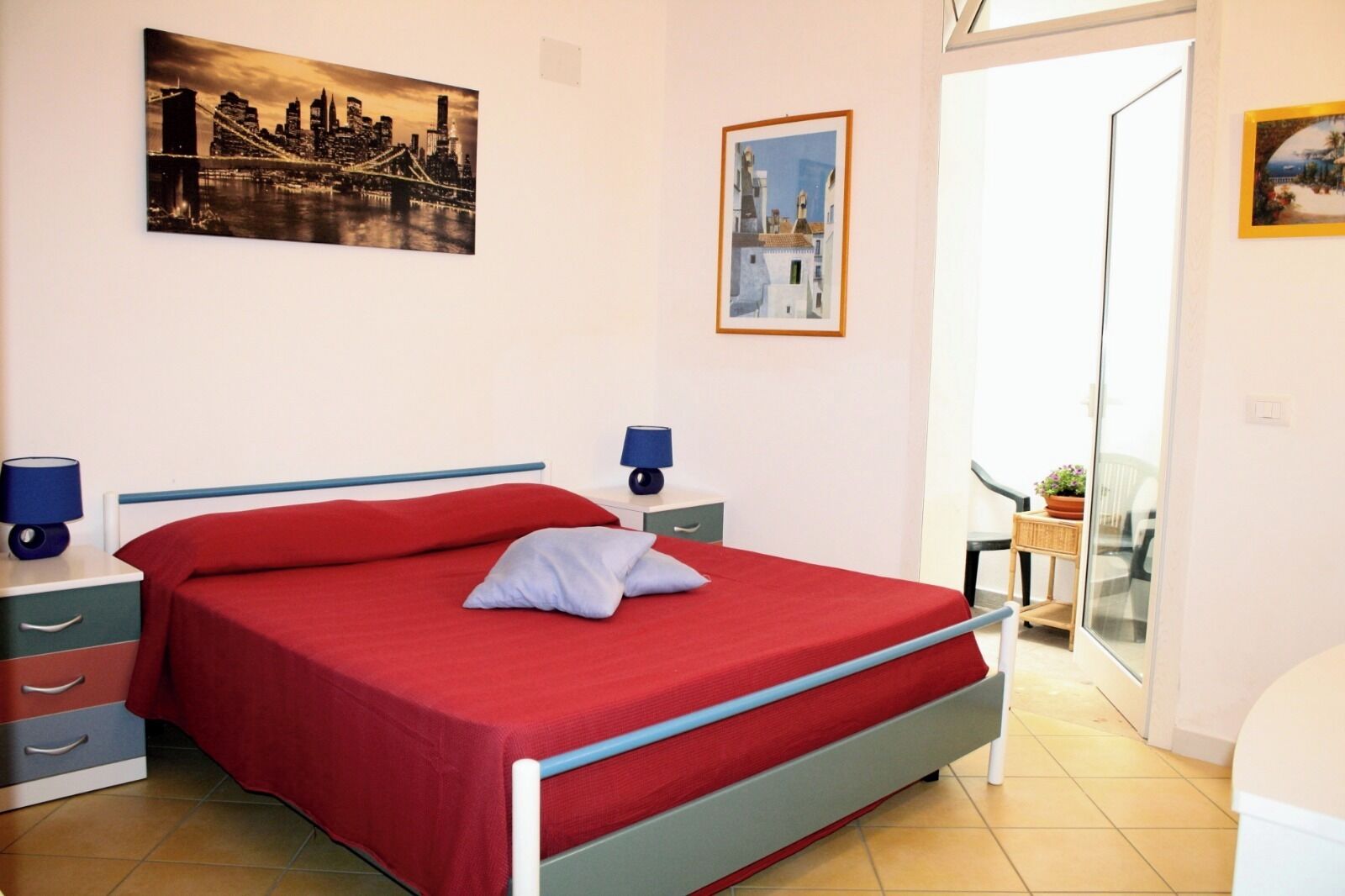 Ein Schlafzimmer mit Bett, Nachttischen, einem Sessel und einem Balkon mit Aussicht.