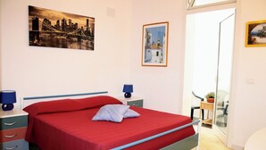 Une chambre à coucher comprenant un lit, des tables de chevet, une commode, une chaise et un balcon avec vue.