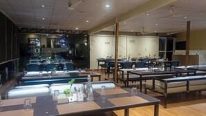 Un restaurante con varias mesas y cabinas, con mantelería y un tablero de menú al fondo.