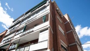A multi-story residential building with balconies, a visible door, and a small window. - Apartmen with Gym 20 min from the center of Madrid (Leganés)