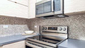 A modern kitchen with a stainless steel stove, oven, and microwave.