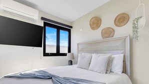 A bedroom with a bed, a window, and wall decor.