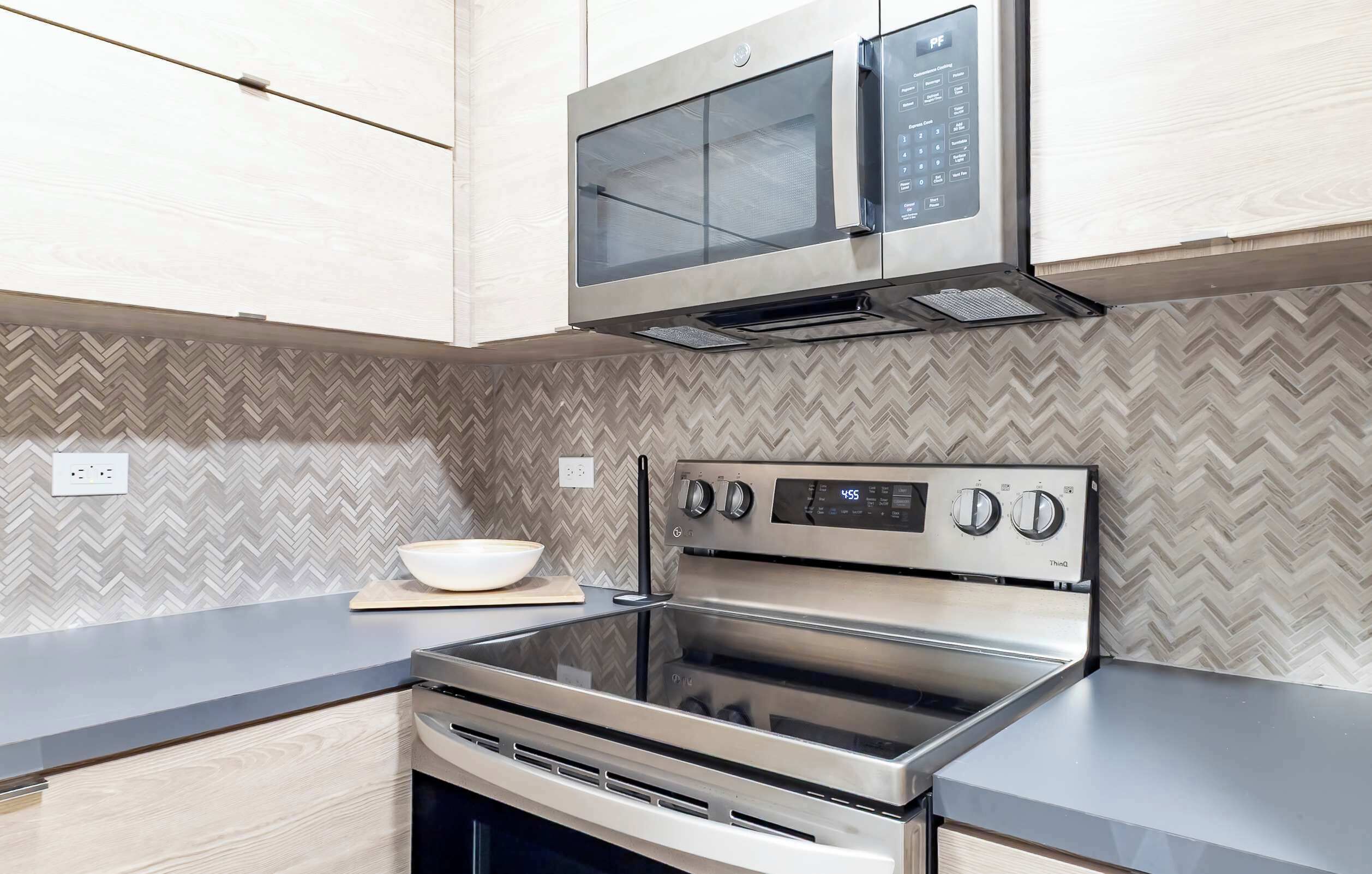 A modern kitchen with a stainless steel stove, oven, and microwave.