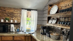 A kitchen with a wooden island, stone flooring, and a stone wall. - NEW LISTING:Spring River:Creek Cabin, Private Footage on South Fork Spring River (Hardy)